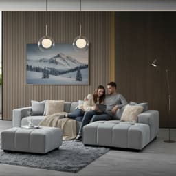 a couple sitting on a right-hand corner sofa looking at a tablet