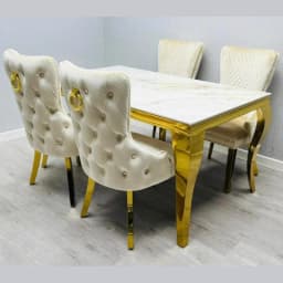 A picture of marble dining table with gold legs and chairs